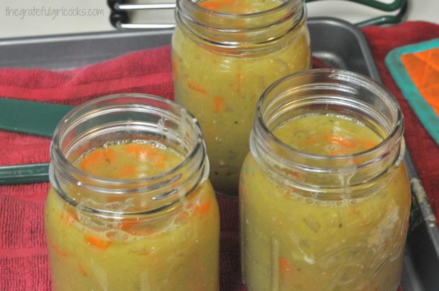 Canning jars are filled with split pea and ham soup for processing.