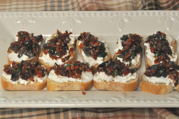 Sun dried tomato kalamata olive bruschetta is almost ready to serve.