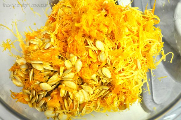 Separating pumpkin stringy flesh from seeds in order to roast pumpkin seeds.