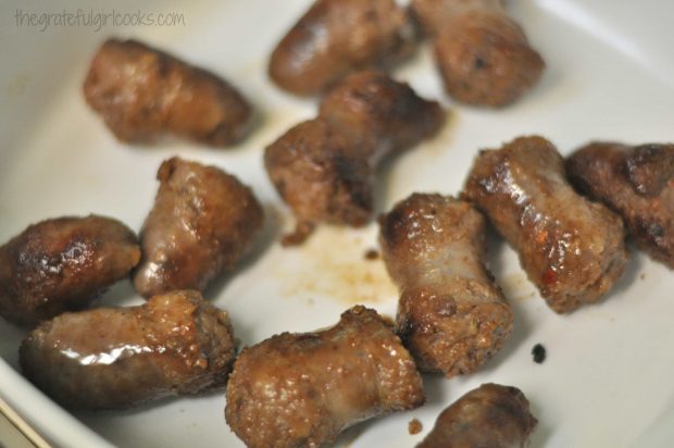 The browned sausage is placed into a baking dish, to begin the casserole.