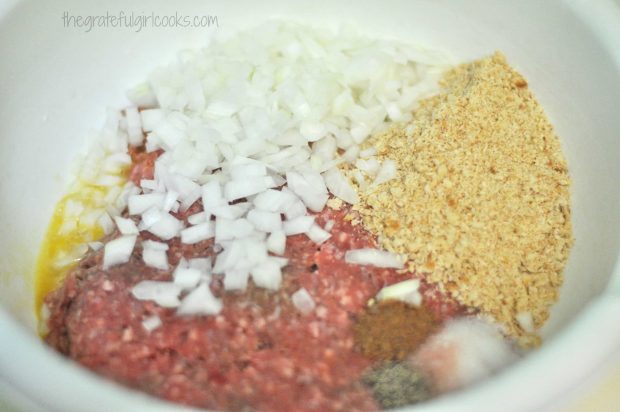 Hamburger meat, onions and spices ready to make Swedish meatballs.