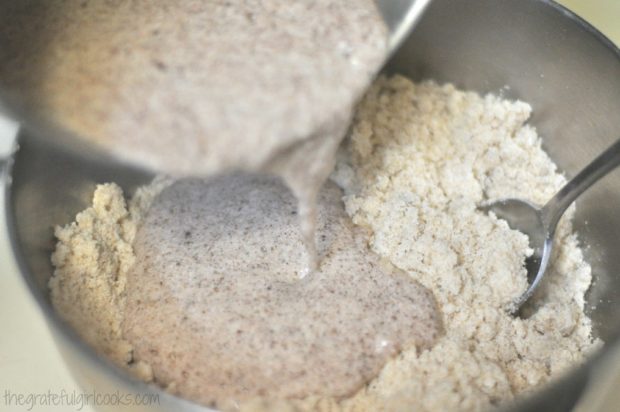 Pouring wet ingredients into dry ingredients in bowl.