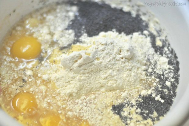 Poppyseeds, cake mix, and eggs in mixing bowl.