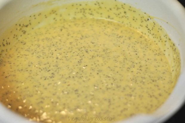 Batter for poppyseed cake in white bowl, and ready to pour into pan.