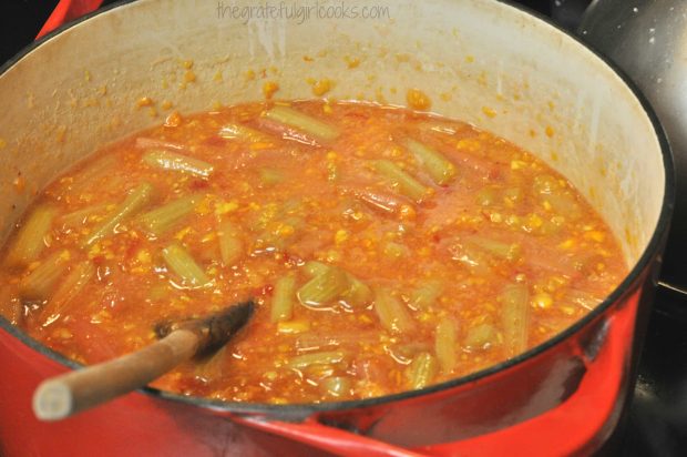 Orange mixture, rhubarb and sugar cooking in large pan.