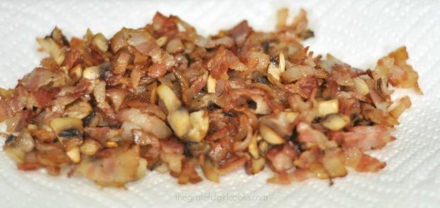 Cooked bacon pieces draining on paper towel