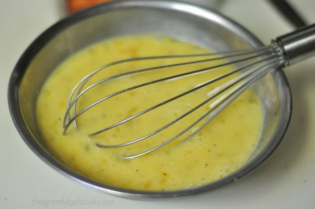 Whisking eggs and milk in metal bowl