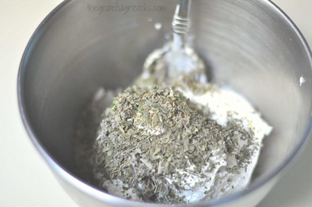 Dried herbs are added to whipped cream cheese to make homemade boursin cheese.