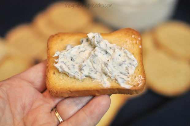 Homemade Boursin Cheese is spread on crisp cracker, to serve.