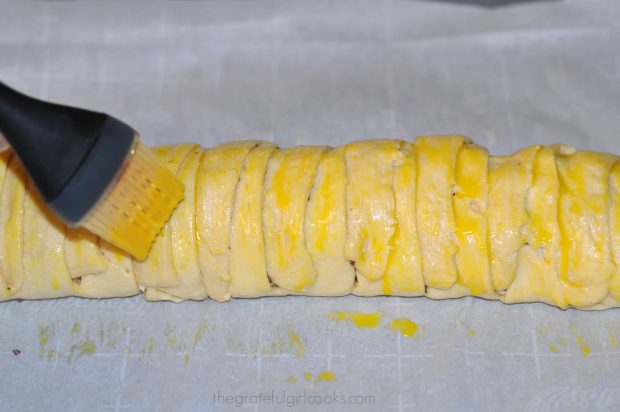 Brushing egg yolk onto the chocolate cream cheese danish. 