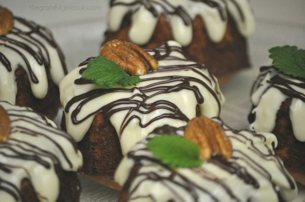 Gingerbread bundt cakes are frosted, then garnished with a pecan and a fresh mint sprig.