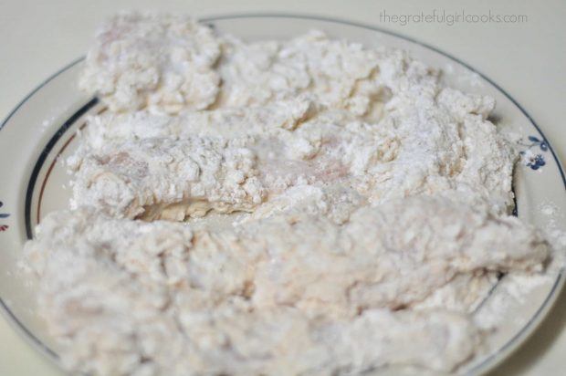 Floured chicken strips resting on plate