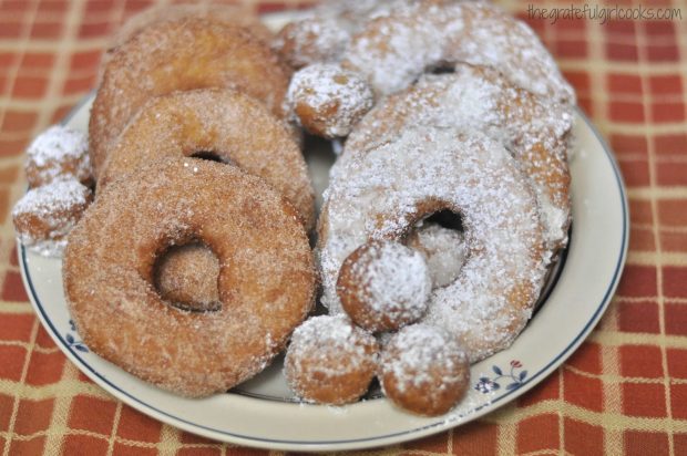 A plate of old-fashioned cake doughnuts and doughnut holes, ready to eat.