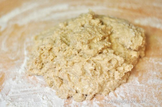 The dough is kneaded together on a floured surface.