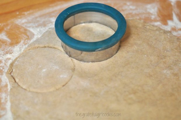 Circles are cut out of the dough with a biscuit or doughnut cutter.