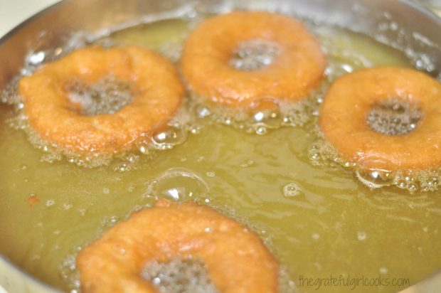 Old-Fashioned Cake Doughnuts are turning golden brown in the hot oil.