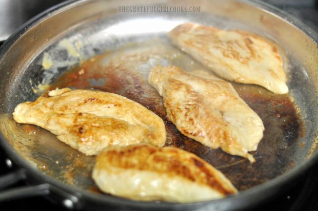 Pan-seared chicken browned on one side in skillet