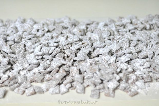 Chocolate Peanut Butter Muddy Buddies are laid on wax paper, to dry.