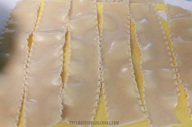 Cooked lasagna noodles are drained then laid in strips.