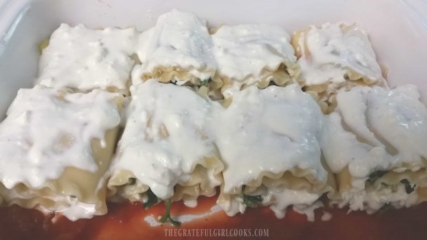 Veggie Lasagna Rollups are rolled, then placed on sauce, and topped with more sauce.