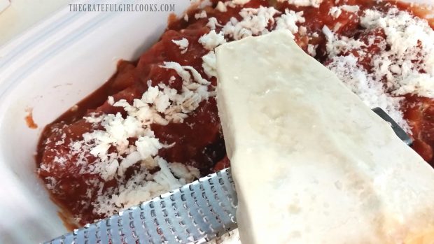 Veggie Lasagna Rollups are covered with marinara sauce and grated Parmesan cheese.