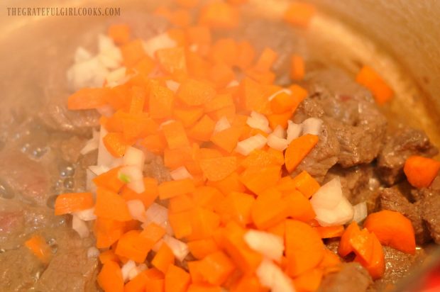 Carrots, onion and beef cooking in pan