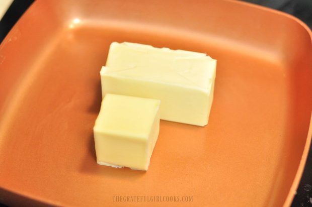 One and a half cubes of butter in a copper skillet