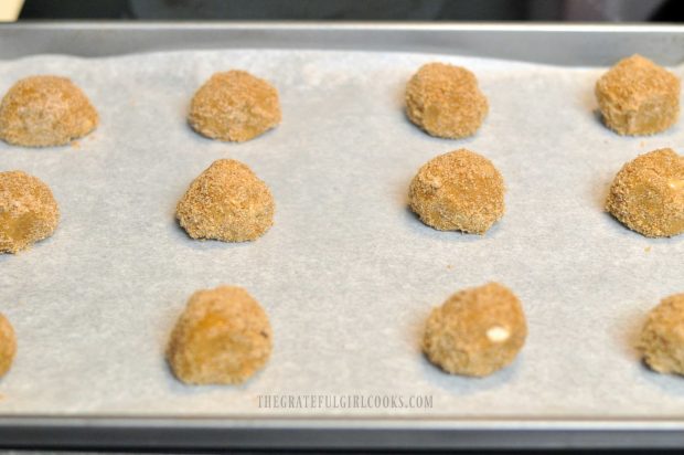 Cookie dough balls on parchment paper lined baking sheet