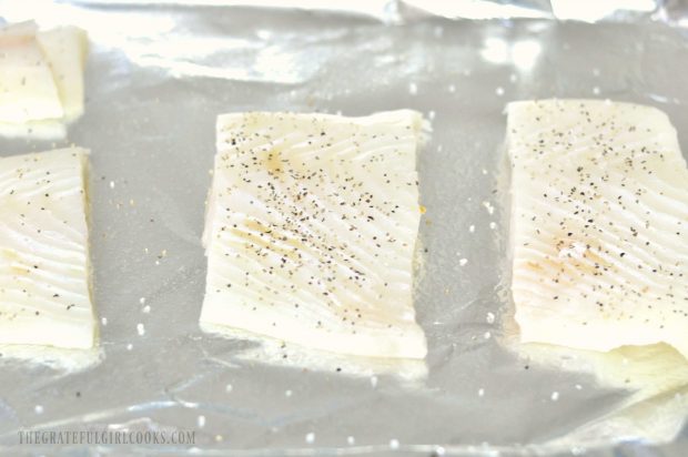 Halibut fillets are blotted dry, then seasoned before cooking.