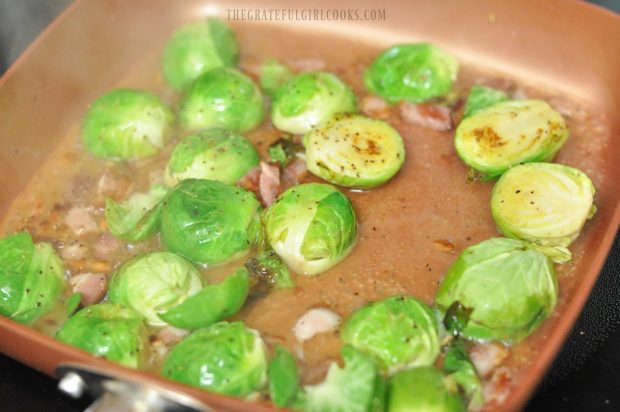 Water is added to brussel sprouts and bacon and cooked until it is gone.
