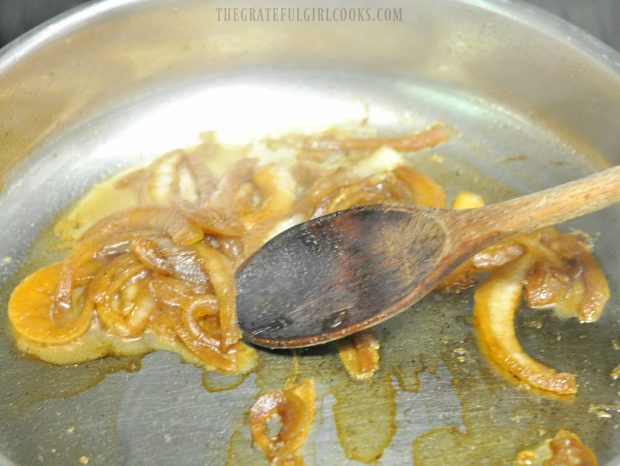 Sliced onions are caramelized in skillet before adding to sandwich.