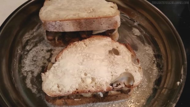 The pork tenderloin sandwich is grilled in a skillet.