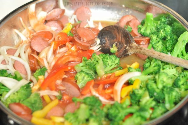 Broccoli, bell peppers and onions are added to smoked sausage veggie rice skillet.