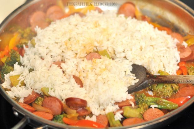 Cooked white rice is added to sausage veggie rice skillet, and stirred to combine.