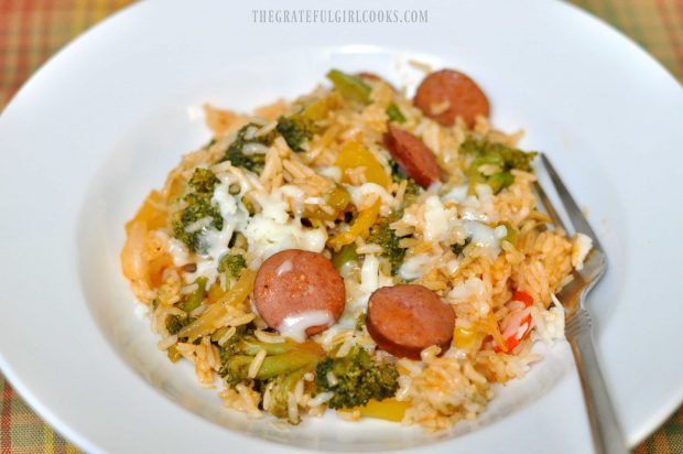 An individual portion of smoked sausage veggie rice skillet dish is served in white bowl.