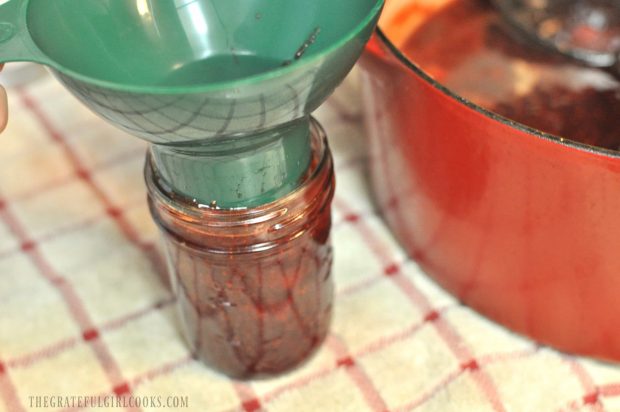 Canning jar being filled with strawberry jam