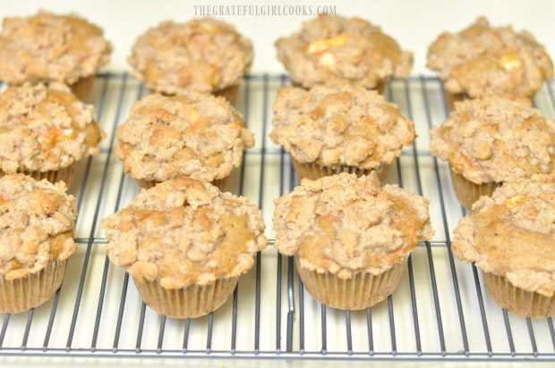 Twelve baked carrot cake muffins, cooling on wire rack
