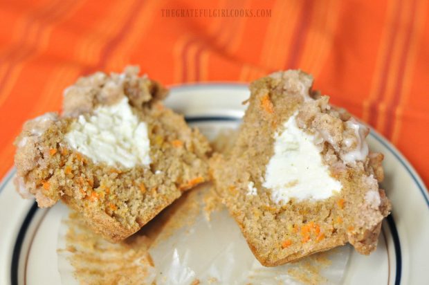 Inside of carrot cake muffin shows cream cheese filling