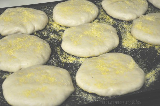 English muffins cooking on a griddle.