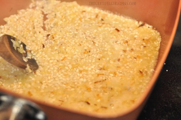 White wine is added to risotto mixture in skillet