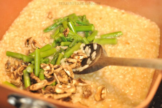 Cooked asparagus and mushrooms added to risotto in skillet