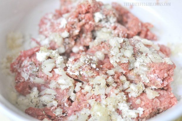 Ground beef is mixed with Parmesan cheese, spices and onions.
