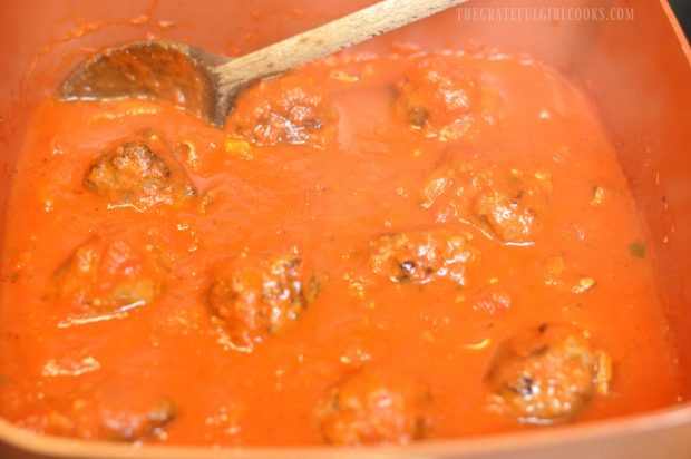 The easy meatballs are covered with spaghetti sauce in pan to finish cooking.