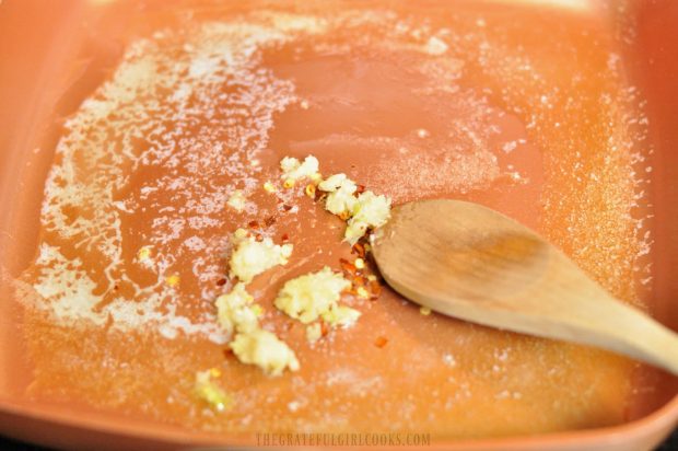 Minced garlic and red pepper flakes are cooked in melted butter.