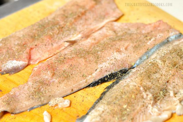 The fish fillets are lightly seasoned before cooking.