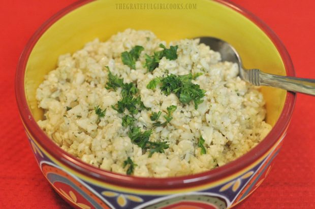 Cauliflower Rice with Parmesan and Garlic in bowl, on a red placemat.