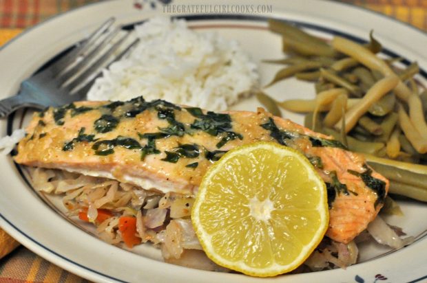 A lemon wedge garnishes a serving of the baked salmon.