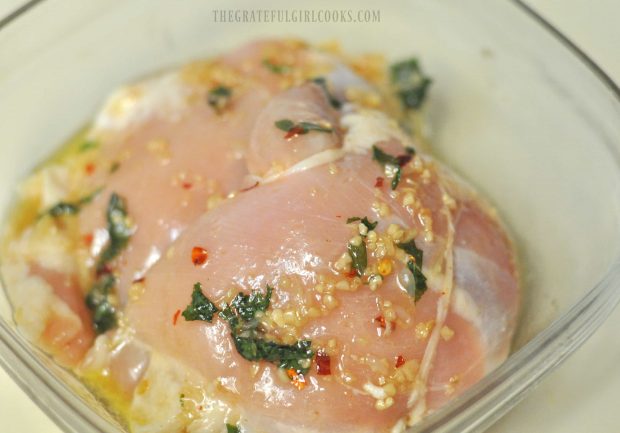 Chicken thighs marinating in glass dish