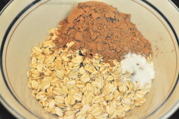 Oats, cocoa powder and sweetener are placed into microwave safe bowl.