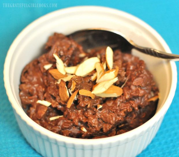 Healthy chocolate oatmeal is topped with almonds after being microwaved.